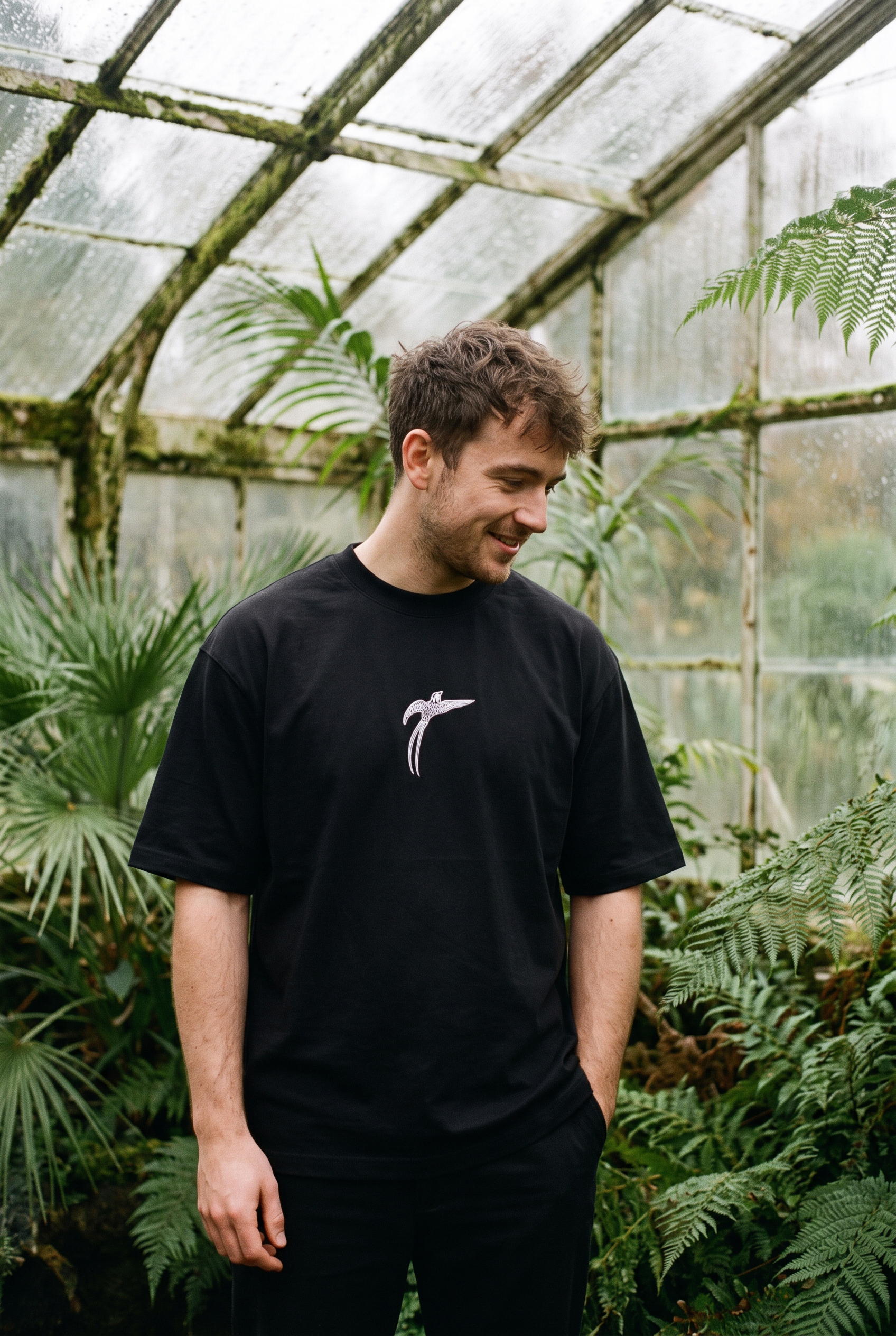 Man wearing the black Bird of Paradise tee, bird print at the chest